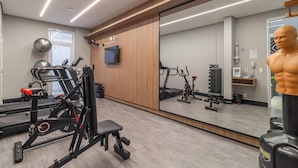 A gym with exercise equipment, a large mirror, and a mannequin. - Seng 106 in S o Paulo (São Paulo)