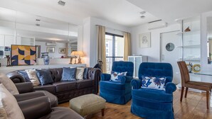 A modern living room with a dark brown leather sofa, two blue velvet armchairs, and a wooden floor. - Ai78-2506 in S o Paulo (São Paulo)
