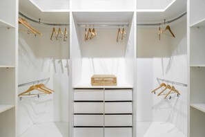 A walk-in closet with multiple wooden hangers and a wicker basket on a central shelf. - Ai78-2506 in S o Paulo (São Paulo)