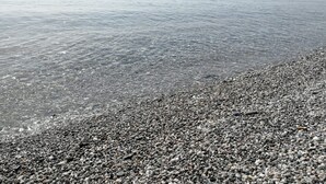 A pebbled beach with calm water and distant boats. - Villa by the sea, perfect for families (Mascali)