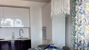 A modern kitchen with white cabinets, a built-in oven, and a stainless steel sink. - Villa by the sea, perfect for families (Mascali)