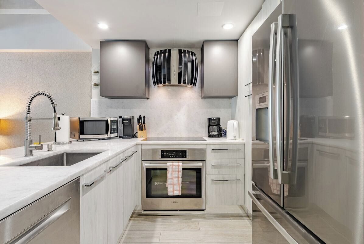 A modern kitchen with stainless steel appliances, a built-in oven, and a microwave.