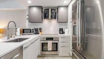 A modern kitchen with stainless steel appliances, a built-in oven, and a microwave.