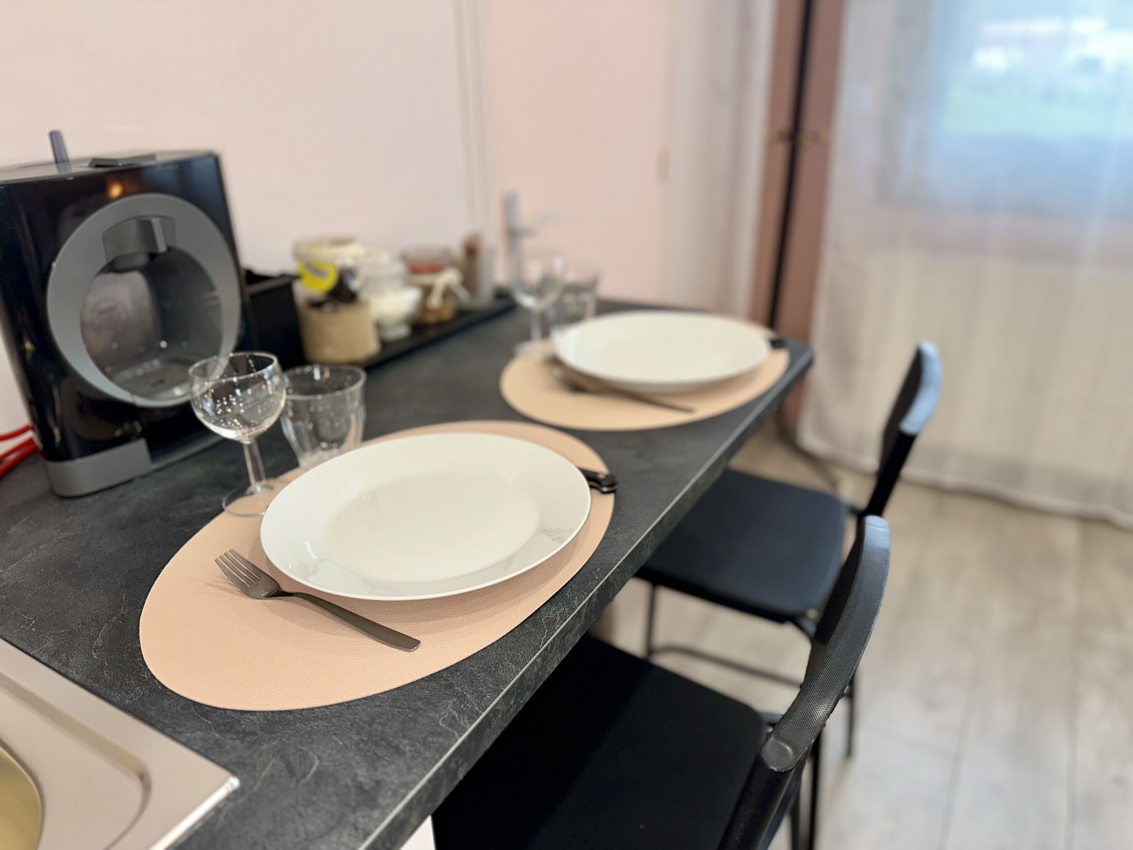 A dining table set with plates, cutlery, and a glass of water.