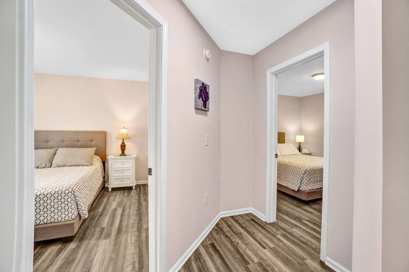 Une chambre à coucher avec un lit, une table de chevet, une lampe et un miroir.