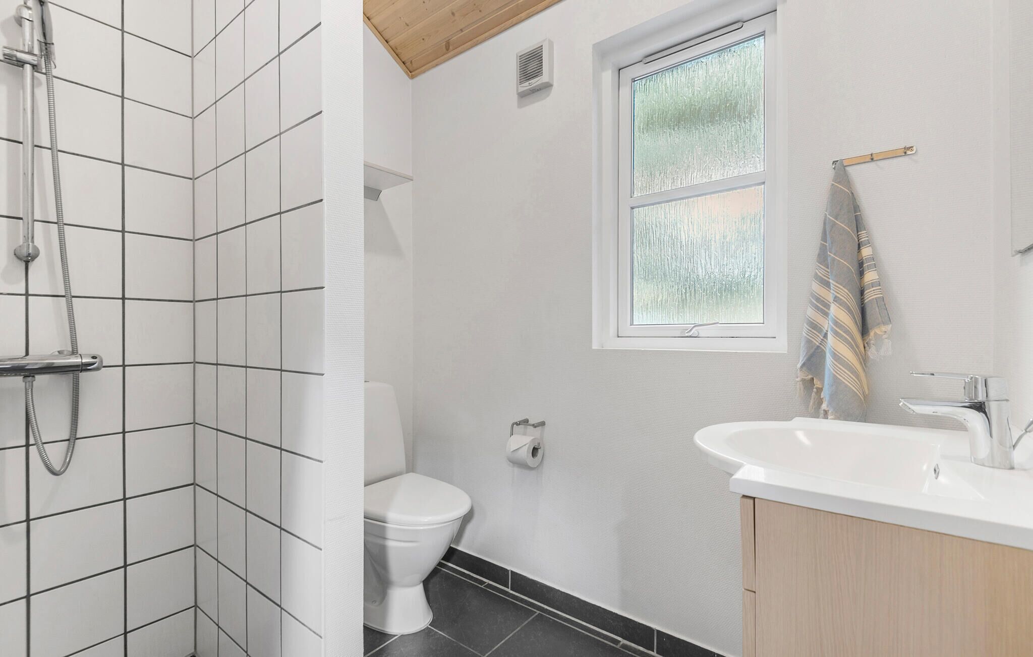 A bathroom with a shower, toilet, and sink.