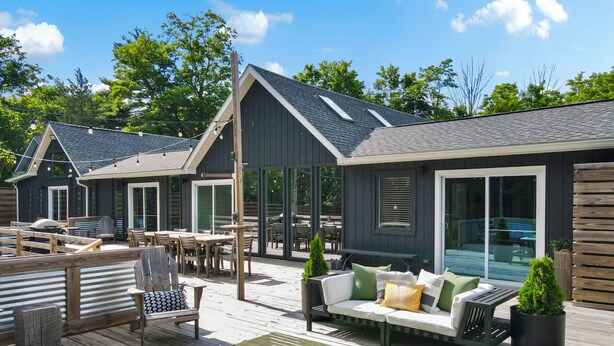 Eine Terrasse mit Sitzgelegenheiten, darunter eine Couch und Stühle, sowie ein kleiner Tisch.