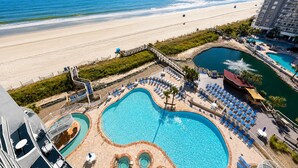 Ein Resort mit großem Pool, einem Strand und Blick auf den Ozean.