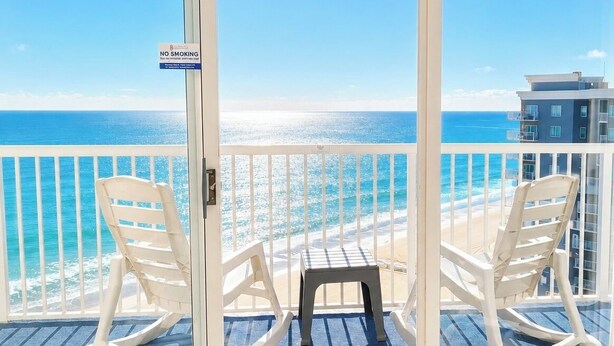 Ein Balkon mit Blick auf das Meer, zwei Schaukelstühle und ein Rauchverbot-Schild.