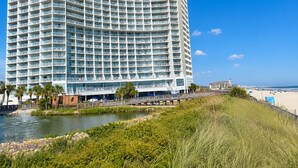Ein großes, mehrstöckiges Hotel mit einer geschwungenen Fassade, in Strandnähe gelegen.