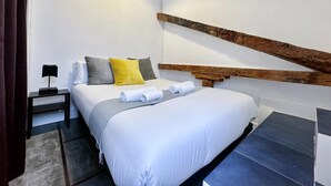 Une chambre à coucher avec un lit, une table de chevet, une tête de lit en bois et une petite table.