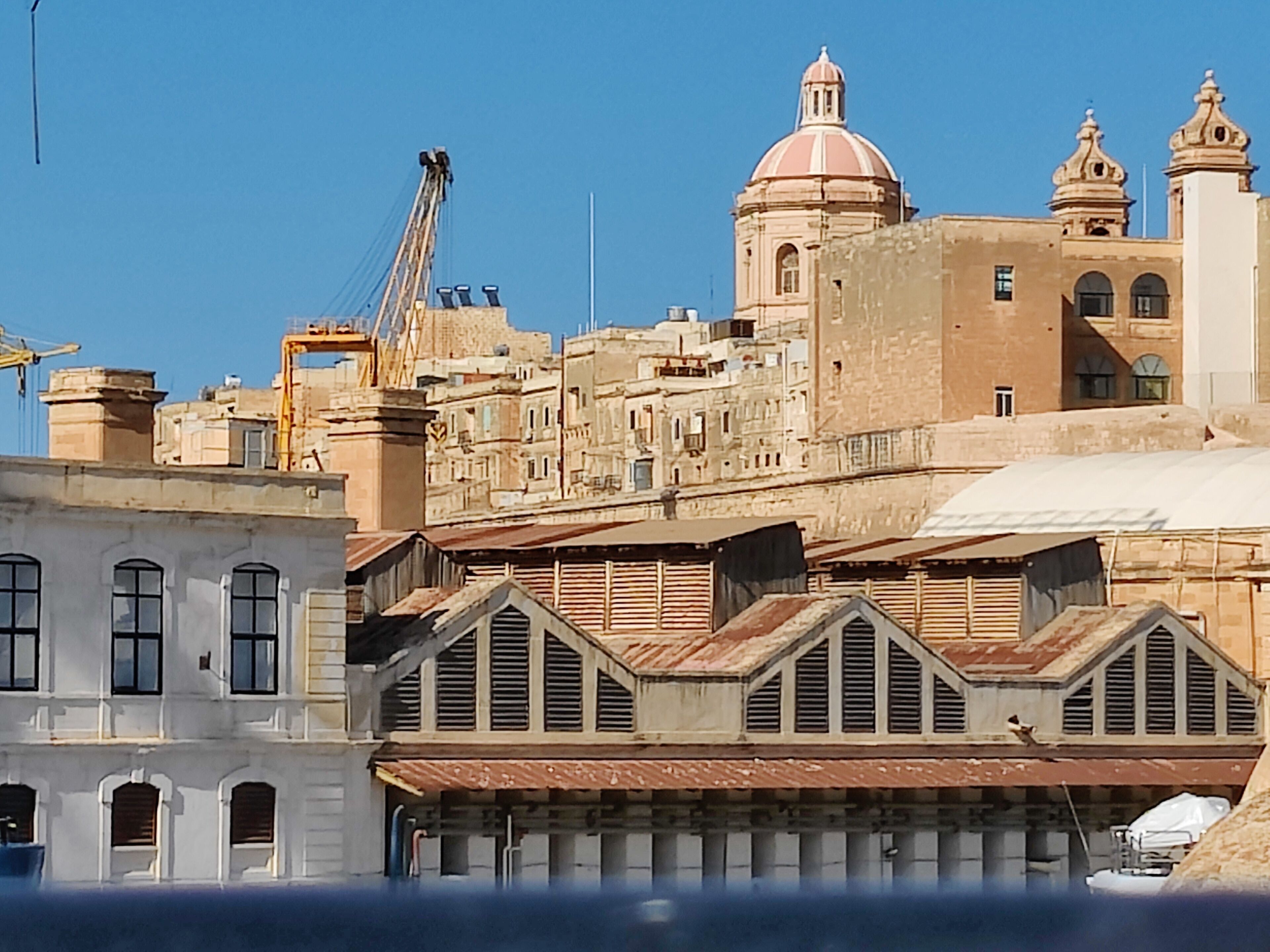 Um edifício histórico com cúpula e torres sineiras, apresentando uma mistura de estilos arquitetônicos.