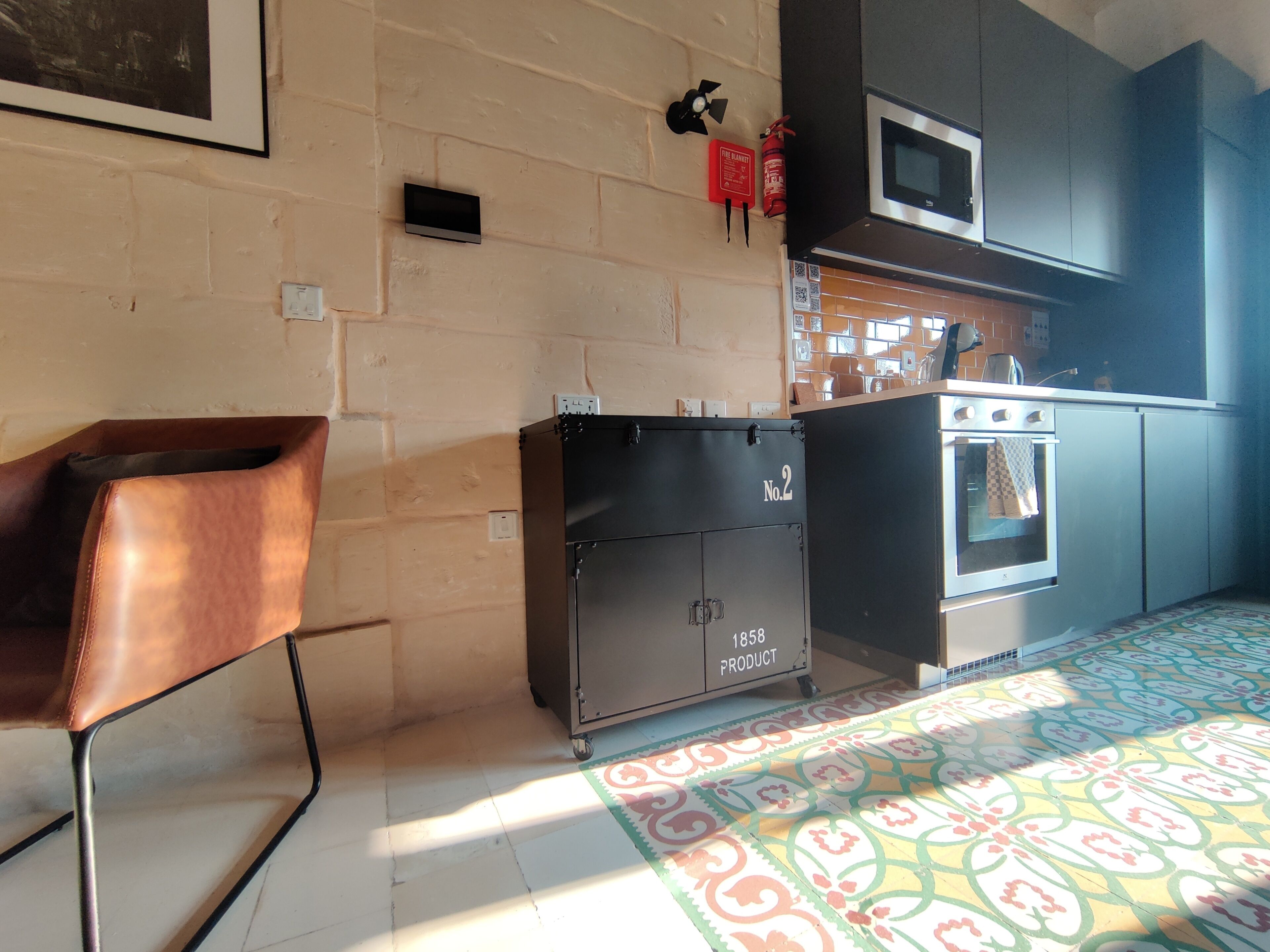 A kitchen with a microwave, oven, and a cabinet labeled 'No.2 1858 PRODUCT'.