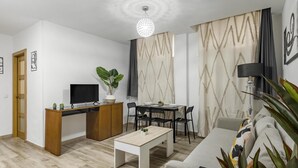 Een moderne woonkamer met een televisie, een eettafel en banken.
