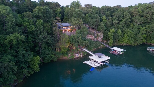 Ein Anwesen am See mit Haus, Steg und Booten.