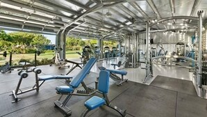 A covered gym with various exercise equipment and a view of the outdoors. - Sunny Poipu Condo w/ A/C close to Beach. Moir Garden and Partial Ocean View #301 (Koloa)