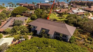 A hotel with a large building surrounded by lush greenery and a view of the ocean. - Sunny Poipu Condo w/ A/C close to Beach. Moir Garden and Partial Ocean View #301 (Koloa)
