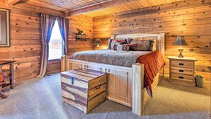 Une chambre confortable dans un chalet en bois, avec un lit en bois, une table de chevet, une commode et une fenêtre avec des rideaux.