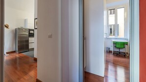 A hallway with a kitchen area, a dining table, and a window. - GuestHost - Comfortable apartment located on the second floor, of six in total, of a building with a lift (NOT suitable for disabled people).In 60 m2 of space it comfortably accommodates three people, with a double bedroom and a single bedroom.Located in (Roma)