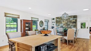 Una cocina amplia con una isla central, armarios de madera y una pared de acento de piedra.
