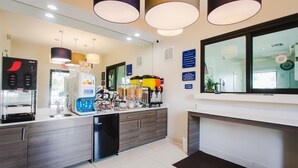 A modern kitchen with a coffee machine, a microwave, and a sink.