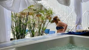 A pool area with a jacuzzi, surrounded by white drapes and plants. - Selva Maria Hotel Boutique (Santa Fe de Antioquia)