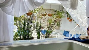 A spa area with a hot tub, white drapes, and potted plants. - Selva Maria Hotel Boutique (Santa Fe de Antioquia)