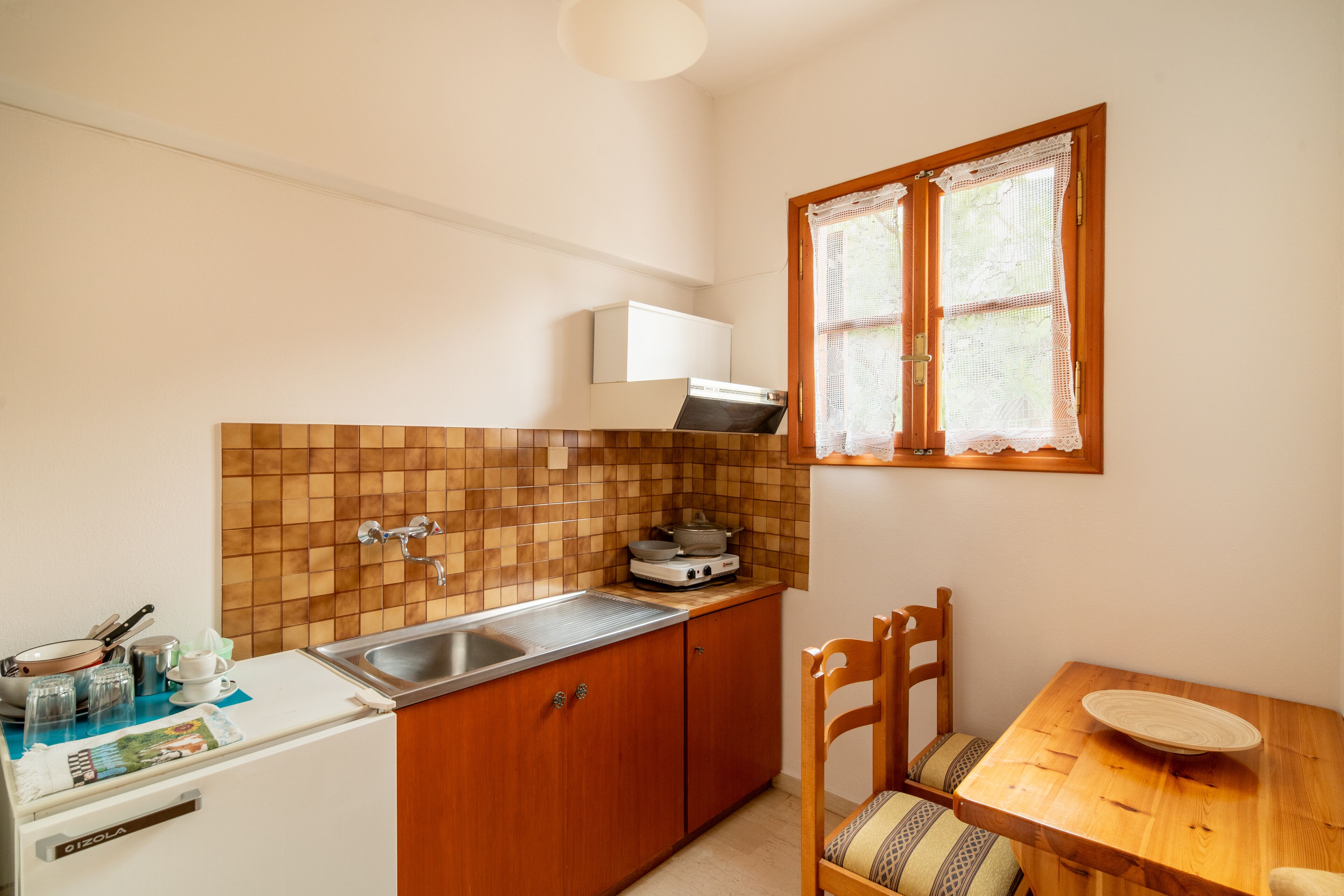 Comfort studio, balkon, uitzicht op tuin | Privékeuken | Een kookplaat, een waterkoker, kookgerei, borden en bestek, keukenpapier