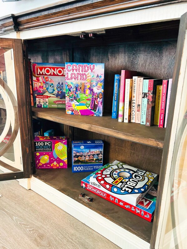 A bookshelf with various board games and books.
