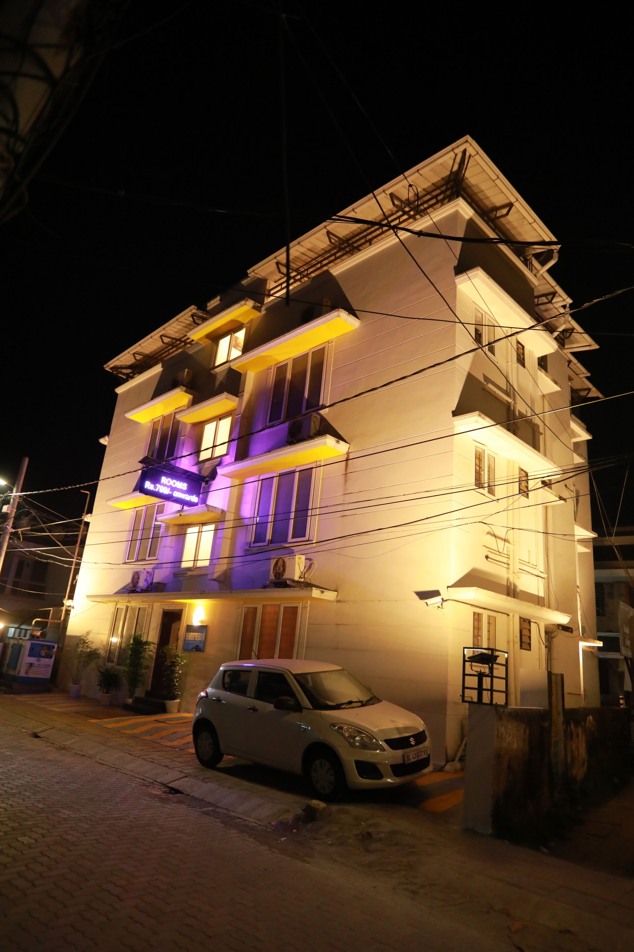 A multi-story building with a car parked in front.