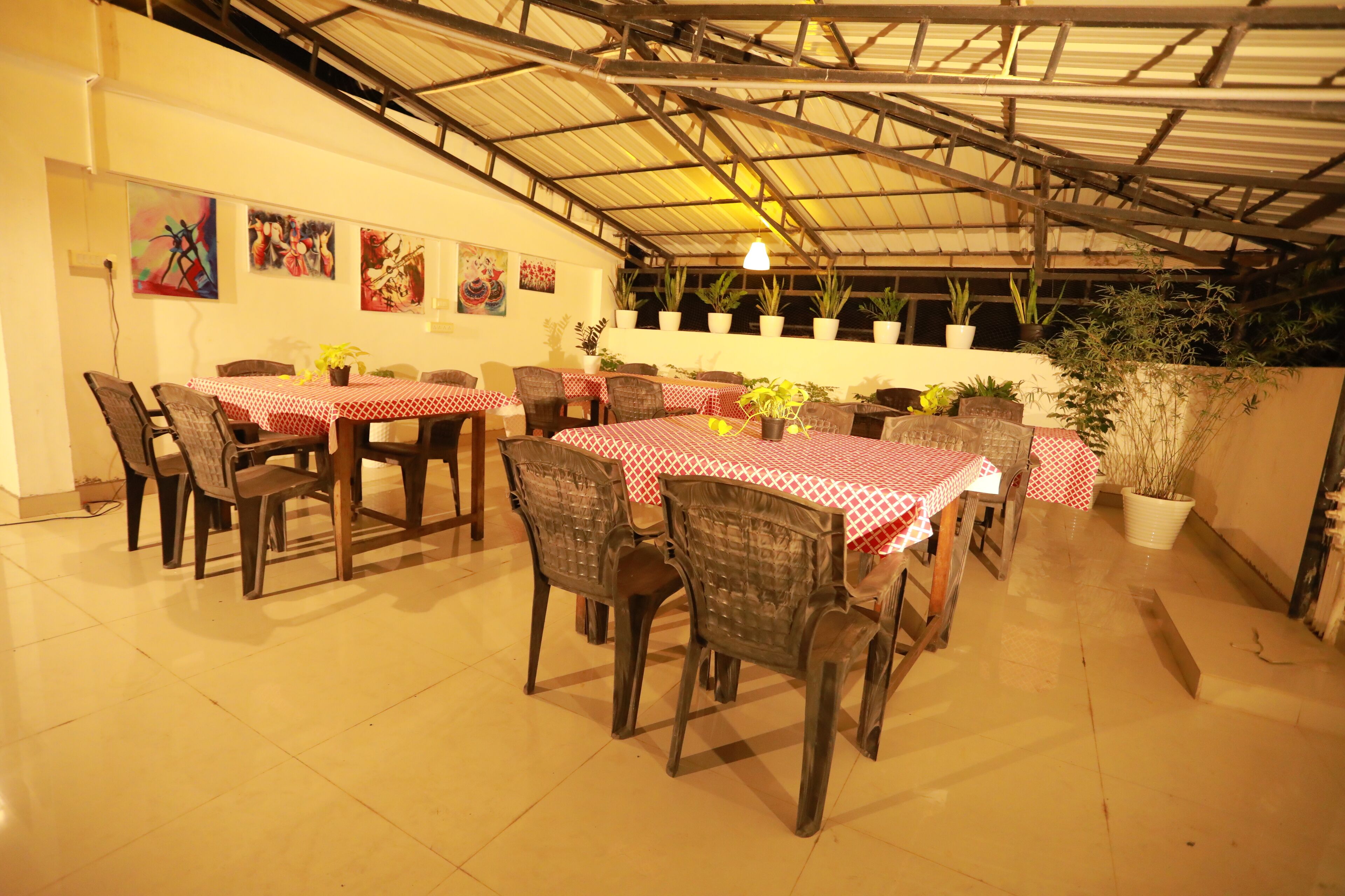 A dining area with tables covered in red and white checkered tablecloths, surrounded by chairs.