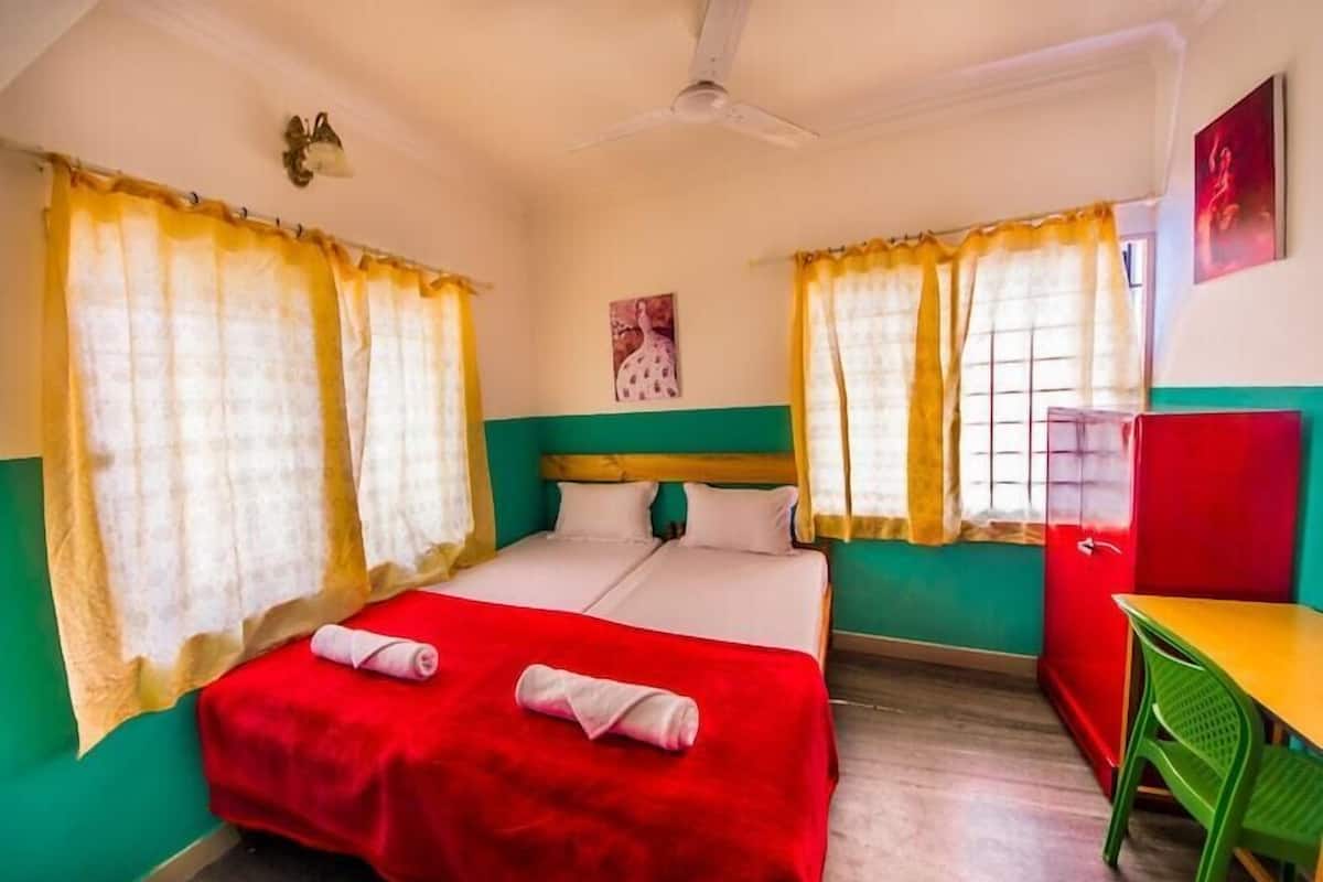 Quarto com uma cama, uma escrivaninha e uma cadeira.