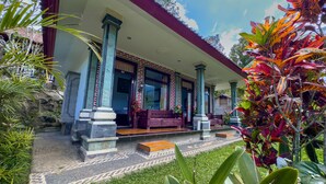 A traditional building with a covered porch, stone columns, and a tiled entrance.
