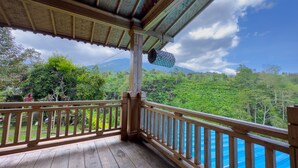 A wooden deck with a view of lush greenery and mountains.
