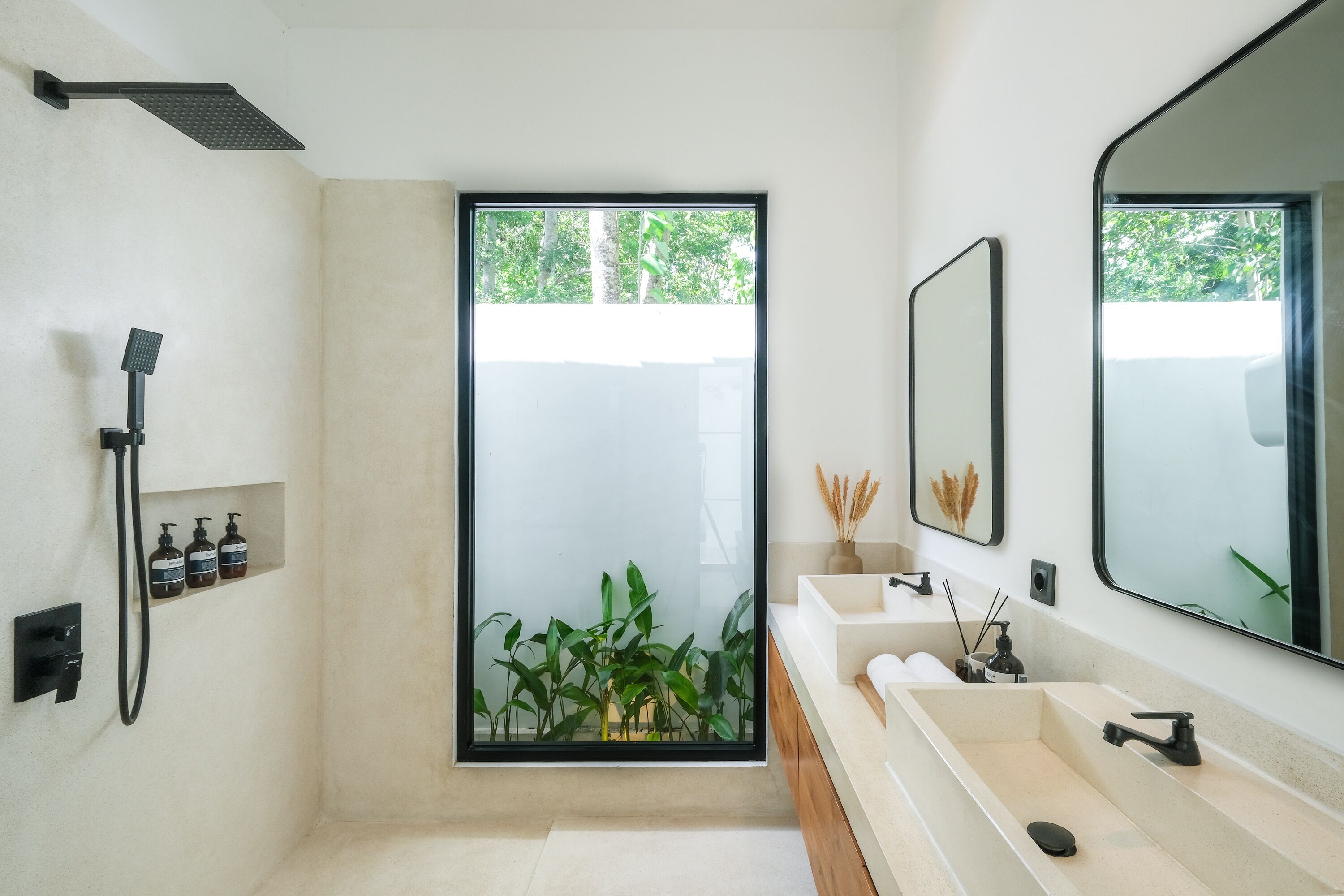 A modern bathroom with a large window, a showerhead, a sink, and a mirror.