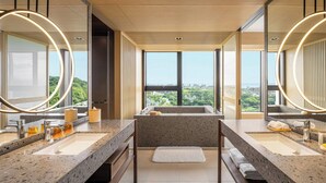 Un bagno moderno con due lavabi, ampi specchi e vista sulla città attraverso grandi finestre.