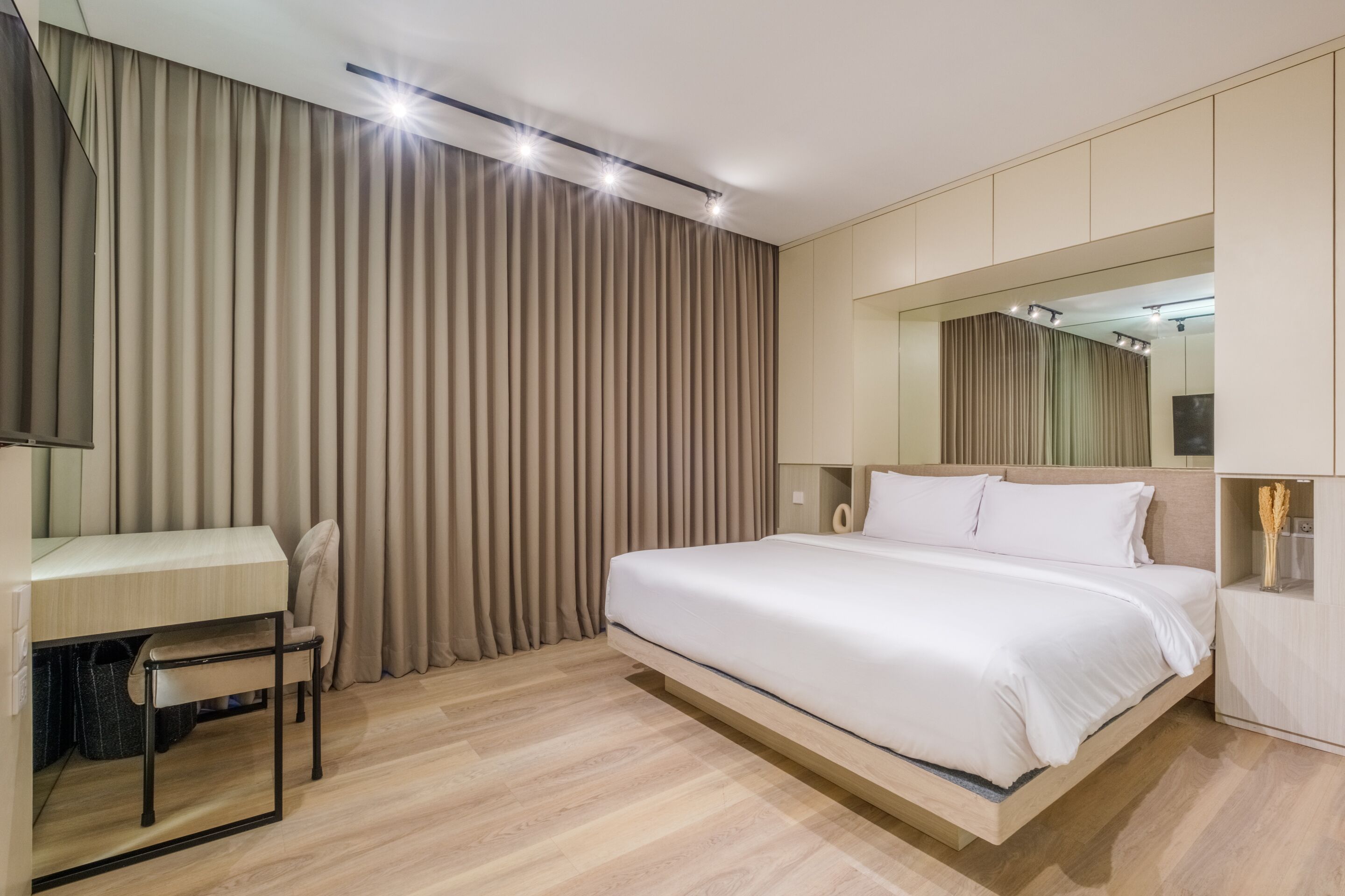 A modern bedroom with a bed, a desk, and a chair.