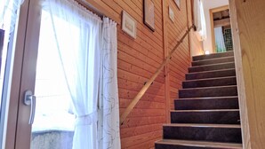 Un escalier en bois, doté d’une rampe, menant à l’étage supérieur.
