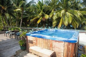 A wooden hot tub on a deck with palm trees in the background. - Crown Regency Beach Resort (Boracay Island)