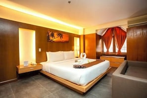 A modern hotel room with a large bed, bedside tables, a desk, and a chair. - Crown Regency Beach Resort (Boracay Island)