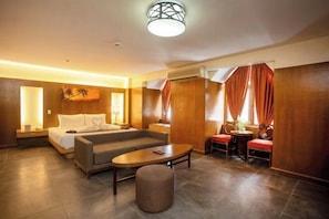 Ein Hotelzimmer mit Bett, Sofa, Couchtisch und einer kleinen Essecke.