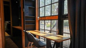 A room with a wooden table and chairs, large windows, and a view of the outdoors. - Stawell Grampians Gate C & C Park (Stawell)