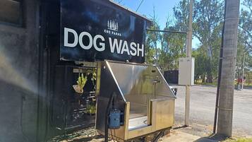 A portable dog wash station with a sign reading 'DOG WASH' and a logo for 'CCC PARKS'.