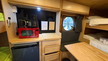 A compact kitchenette with a microwave, coffee maker, and a small refrigerator.