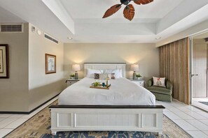 Ein geräumiges Schlafzimmer mit einem großen Bett, einem Deckenventilator und Blick ins Freie.