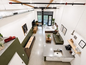A modern interior with a kitchen area, seating, and artwork.
