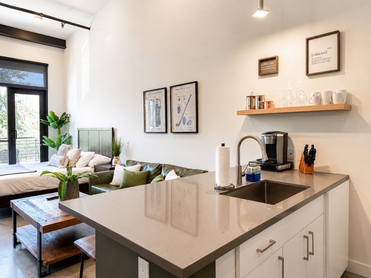 Uma cozinha moderna com ilha central, pia embutida e espaço para café.