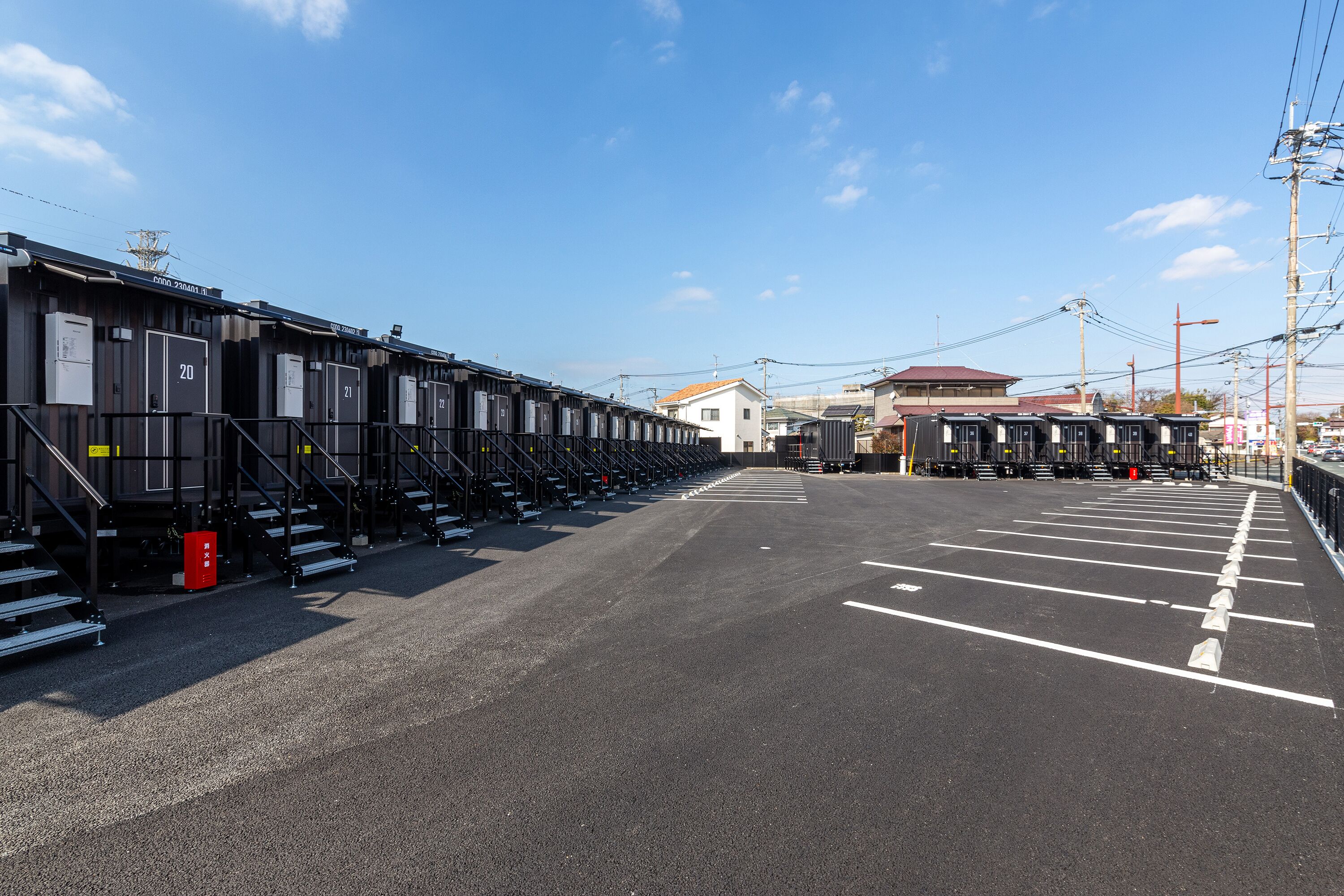 Een parkeerterrein met rijen geparkeerde treinen en een gebouw op de achtergrond.
