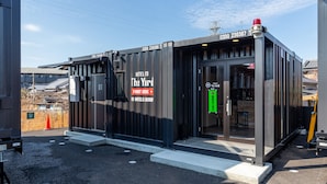 A modern hotel with a glass facade, labeled "The Yard" and "19 Hotels Group." - HOTEL R9 The Yard Arao (Arao)