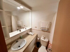 A bathroom with a sink, mirror, toilet, and towel rack. - Hermoso y Acogedor Apartamento en el Tabo, Tranquilo y Agradable (El Tabo)